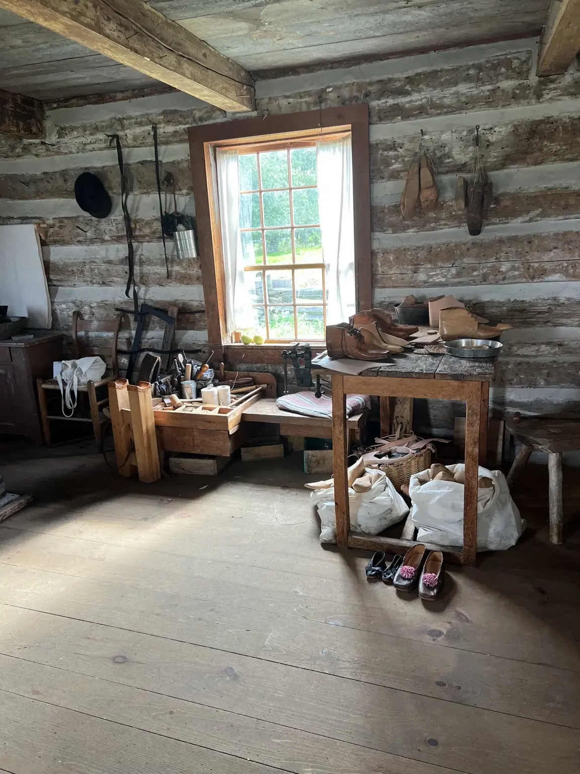 Shoemaker’s workshop at Upper Canada Village, with shoes, tools, and workbenches lit by a central window